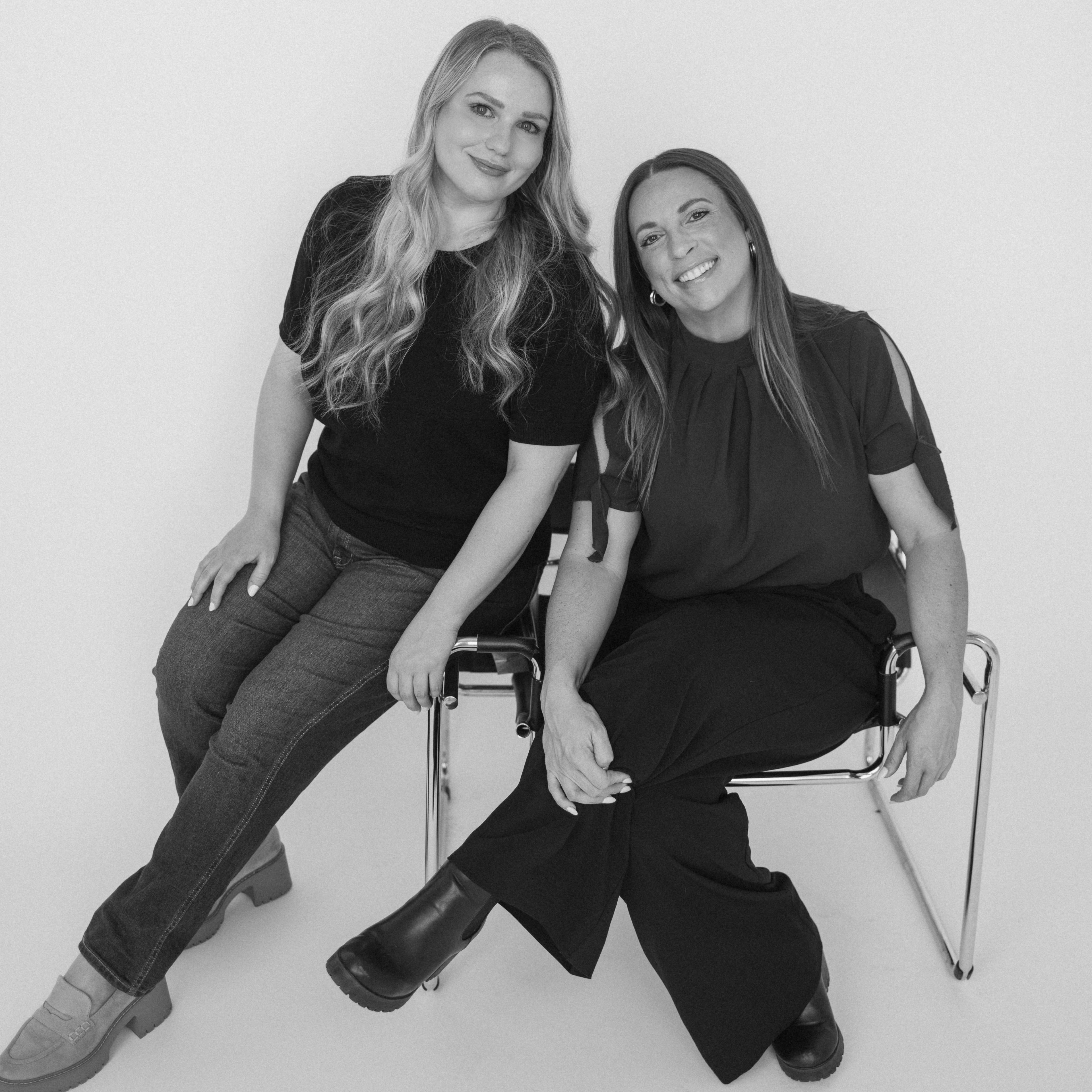 Two women sitting on chairs against a white background