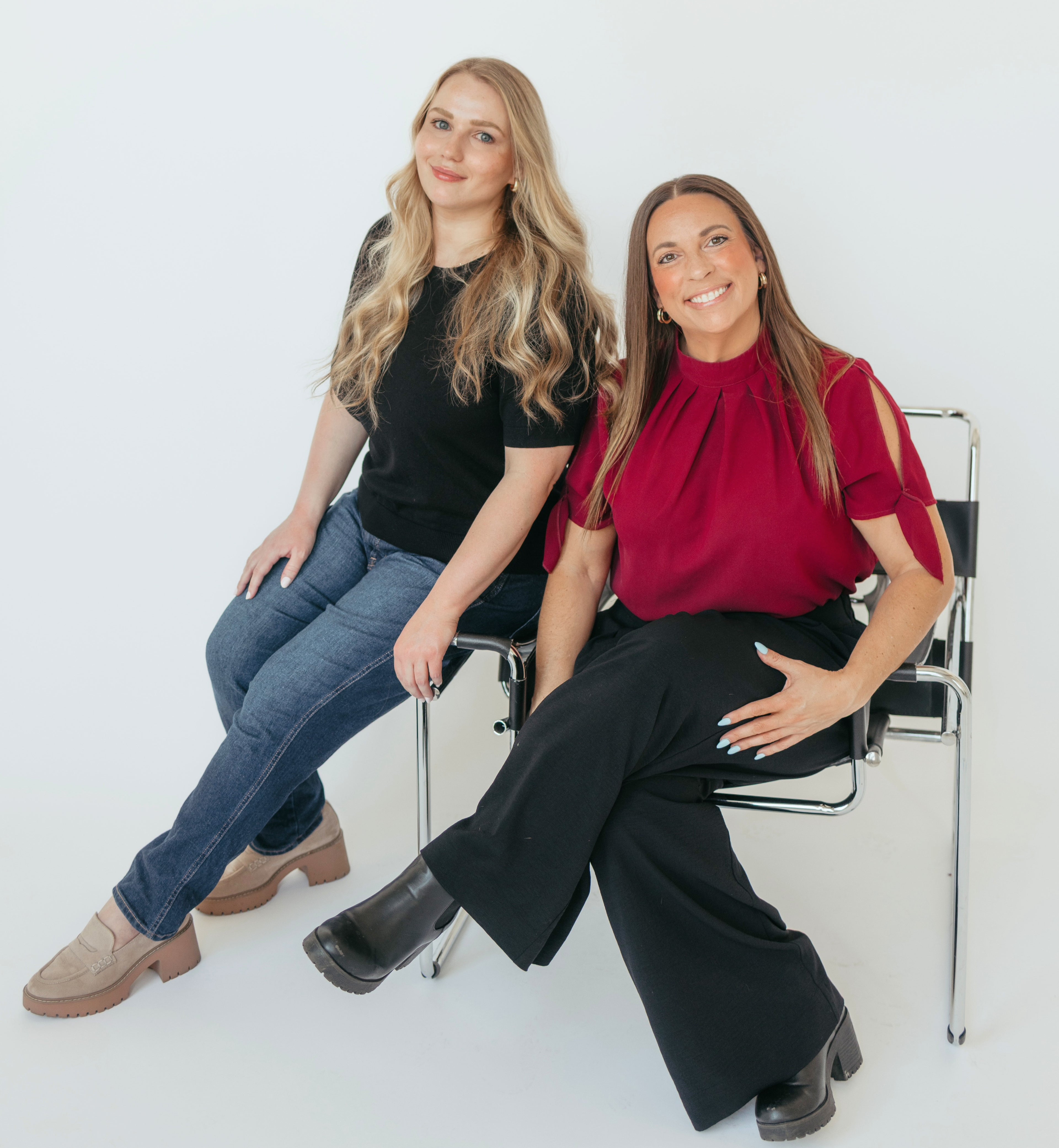 Two women sitting on chairs against a white background